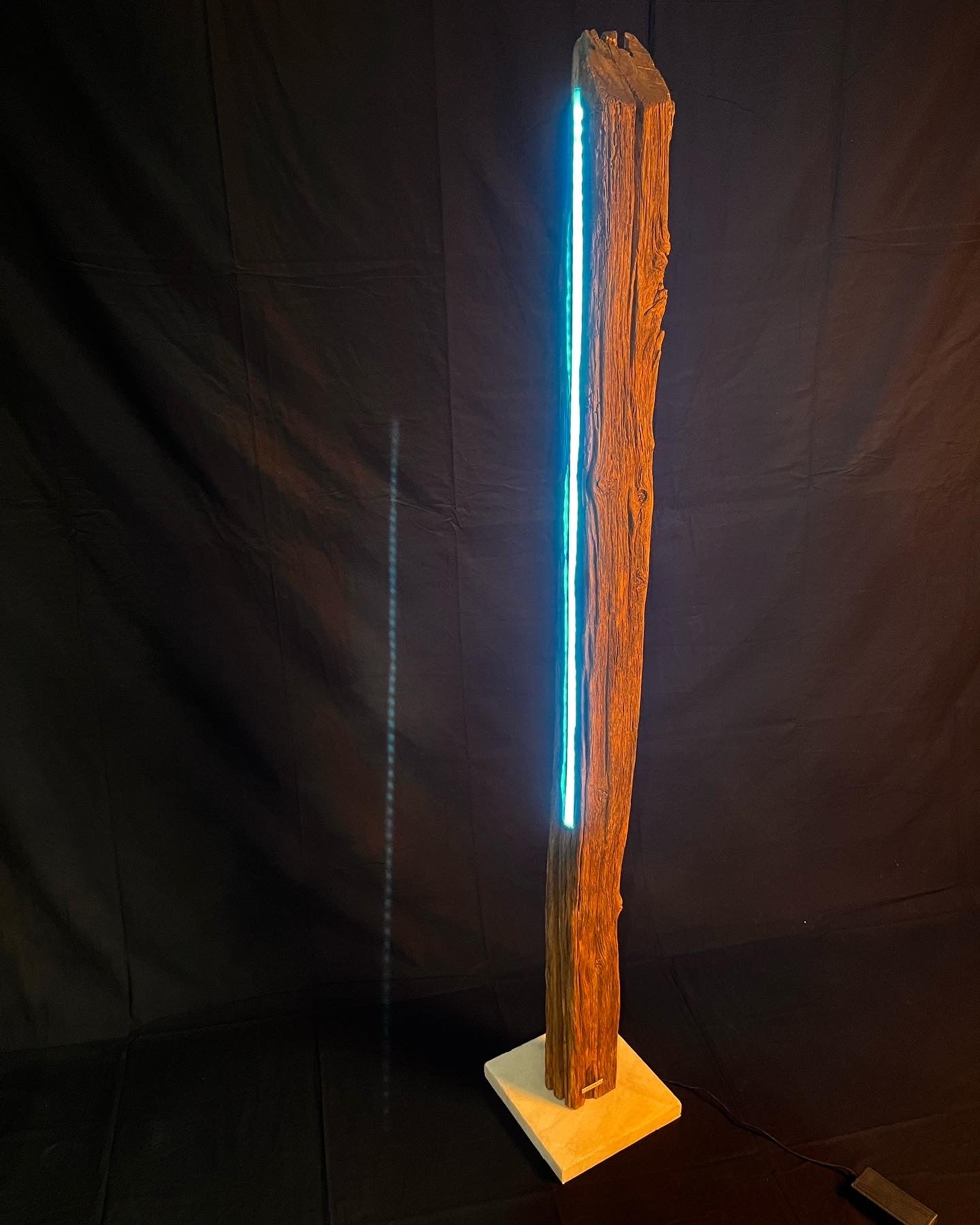The lamp with 2 LED strips made of 450-year-old oak with a white LIFTER marble base